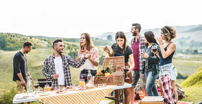 Happy adult friends eating at picnic lunch in italian vineyard outdoor - Young people having fun on gastronomic weekend tuscany tour - Friendship, summer and food concept - Focus on center guys Happy adult friends eating at picnic lunch in italian vineyard outdoor - Young people having fun on gastronomic weekend tuscany tour - Friendship, summer and food concept - Focus on center guys