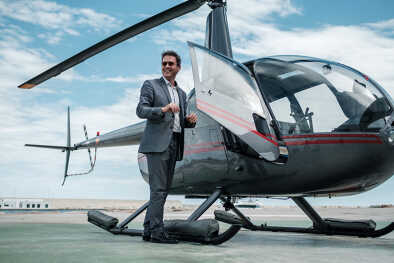 Businessman standing near private helicopter Businessman standing near private helicopter