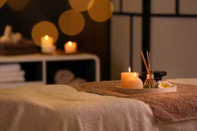 Brennende Kerzen und aromatischer Reed-Erfrischer auf dem Tisch im Spa-Salon in St. Anton Brennende Kerzen und aromatischer Reed-Erfrischer auf dem Tisch im Spa-Salon in St. Anton