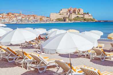 Parasols on the sandy beach of Calvi in Corsica Parasols on the sandy beach of Calvi in Corsica