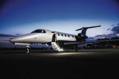 Embraer Jet Phenom 300E на асфальте ночью с разложенной лестницей Embraer Jet Phenom 300E на асфальте ночью с разложенной лестницей