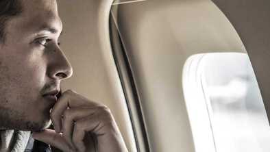 white men looking through a plane porthole white men looking through a plane porthole