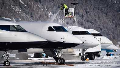 A man removing the ice on the top of an aircraft. This operation is called deicing de-icing A man removing the ice on the top of an aircraft. This operation is called deicing de-icing