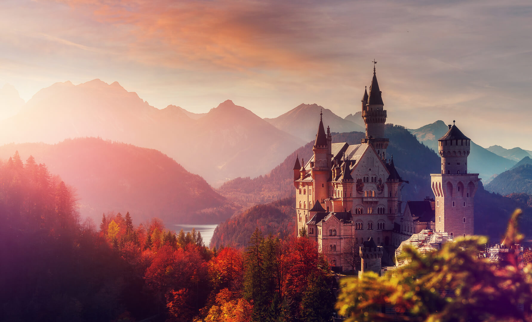 Tipical postcard. Majestic Neuschwanstein castle during sunset, with colorful clouds under sunlight.