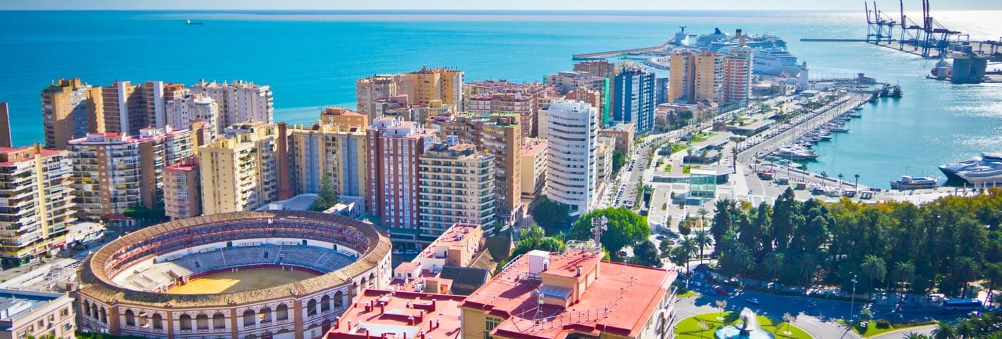 Sunny view of Malaga and its Malagueta bullring with the sea and harbour in the background