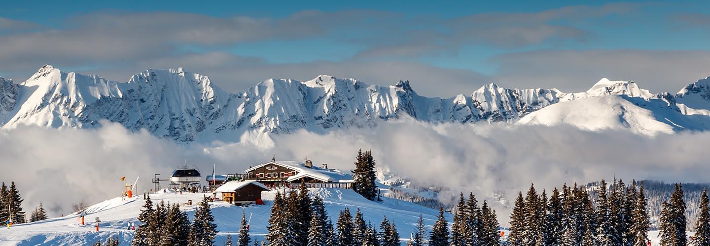 Photo of the top of a ski resort in Megève in France with snowy mountains in the background