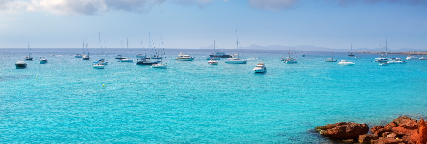 Photo of a bay in Formentera in Spain with many pleasure boats moored