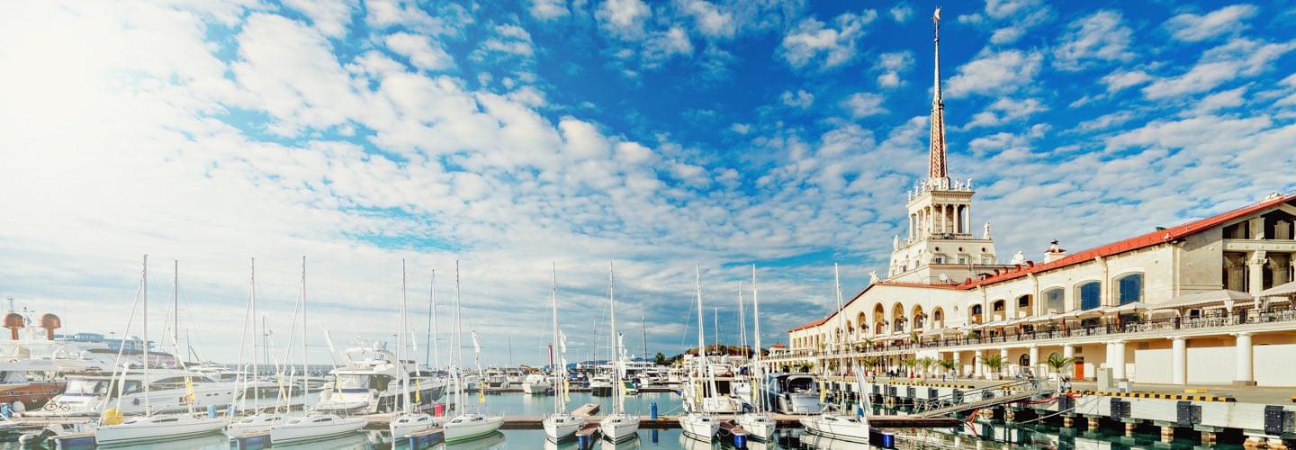 Sochi Sea Port with boats and cloudy blue sky and the Sochi Grand Marina Burevestnik Group