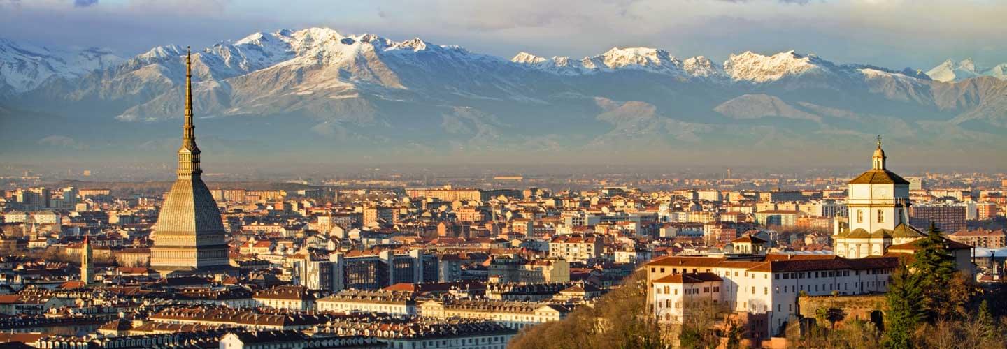 Vue aérienne des toits de Turin en Italie au couché du soleil avec des montagne enneigée à l'arrière plan