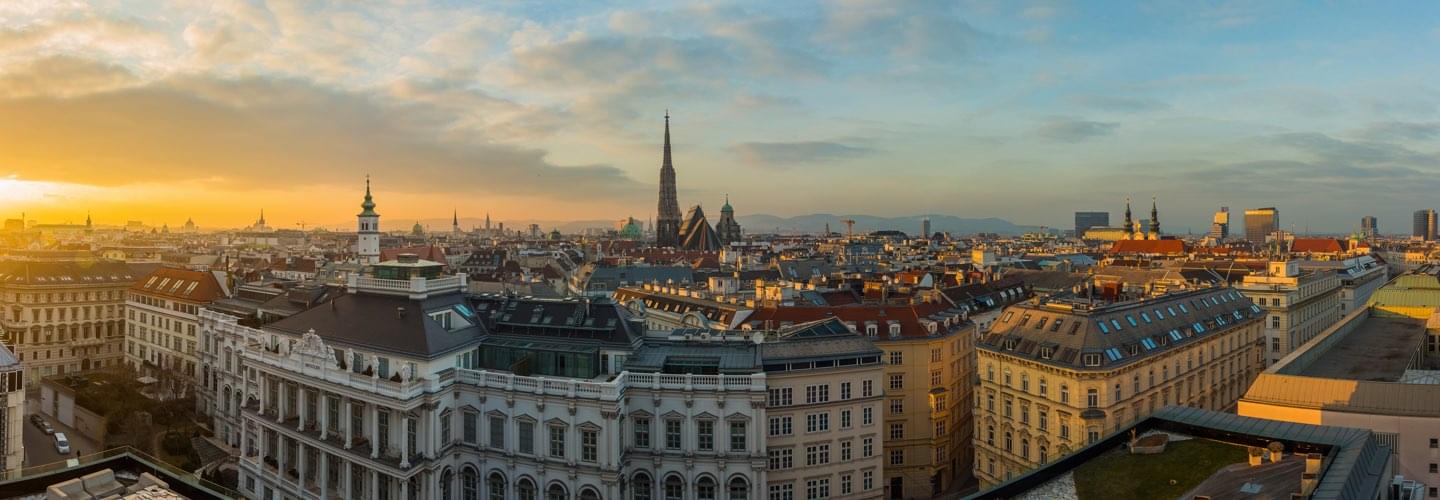 Aerial view of the roofs of Vienna in Austria at sunset. In the background a cathedral