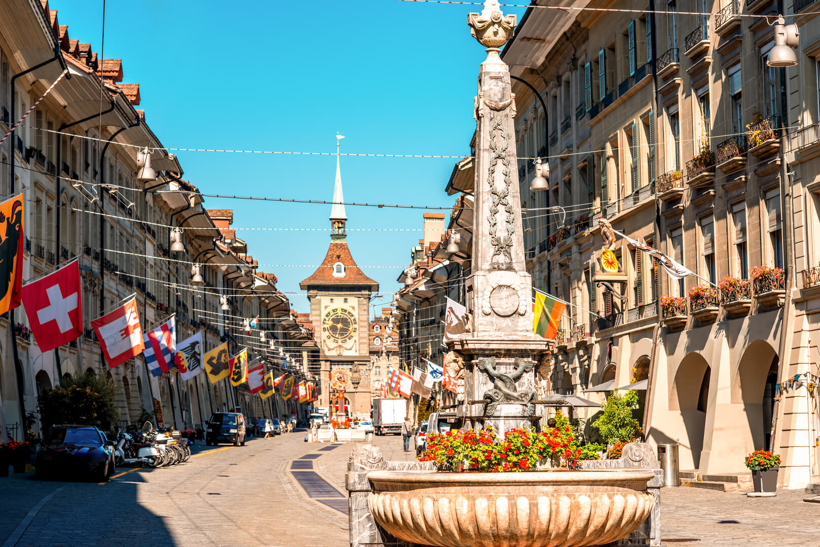 Street view on Kramgasse with fountain and clock tower in the old town of Bern city. It is a popular shopping street and medieval city centre of Bern, Switzerland