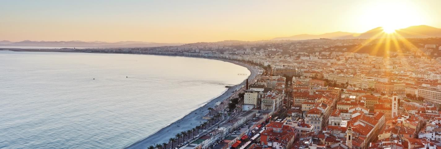 Sunset in Cannes with Promenade des Anglais and surrounding buildings and the Mediterranean sea
