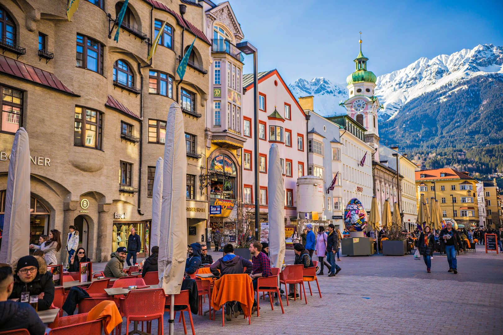Centre ville d'Innsbruck avec beaucoup de monde et des cafés de rue décorés pour les fêtes de Pâques avec de gros œufs de Pâques, Innsbruck, Tyrol, Autriche.