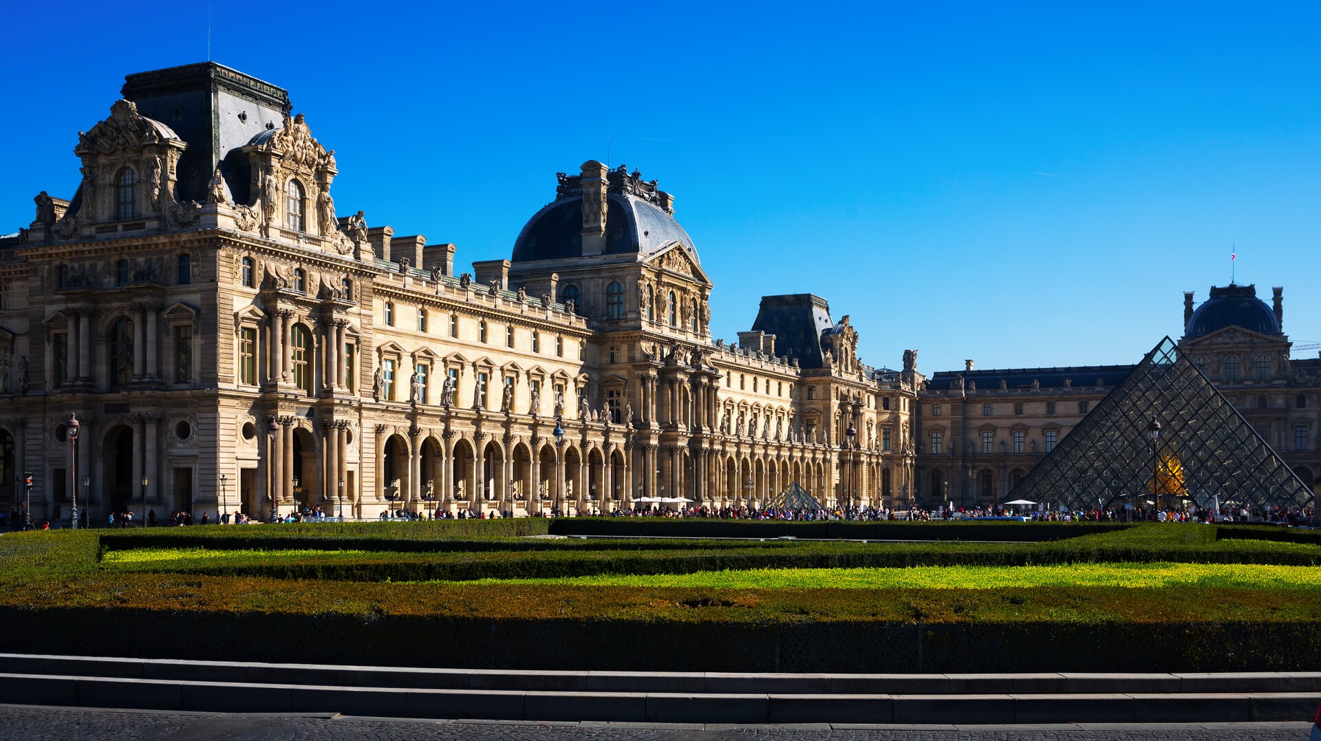 Panoramic view of the main courtyard of the Palais du Louvre with pyramid on a sunny autumn day