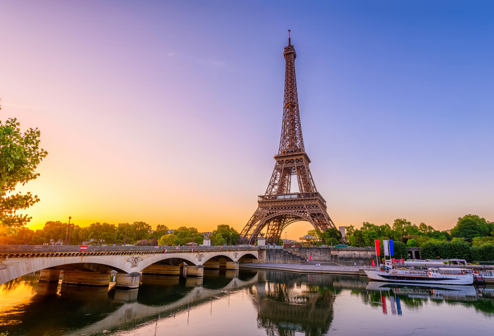 View of Eiffel Tower and river Seine at sunrise in Paris, France. Eiffel Tower is one of the most iconic landmarks of Paris. Architecture and landmarks of Paris. Postcard of Paris
