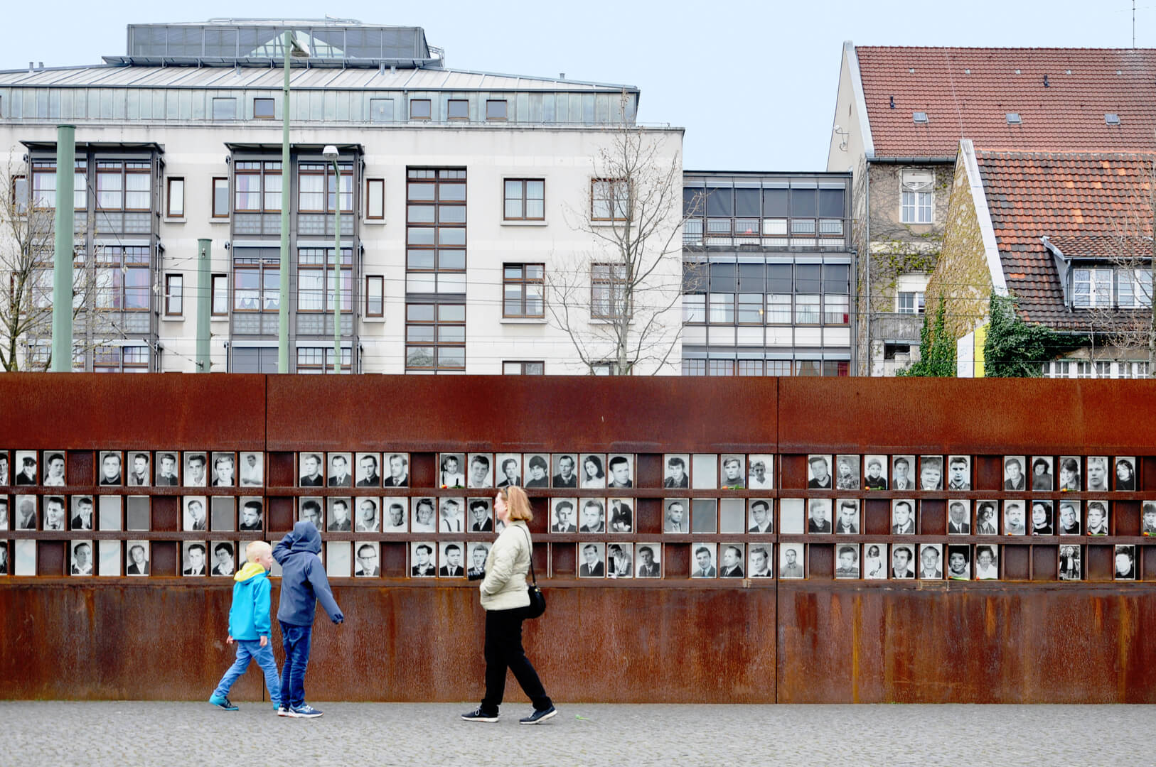 Monument of the Berlin Wall with photos of people and visitors.