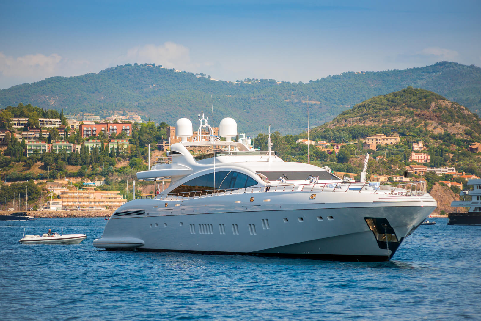 Grand yacht à moteur blanc ancré dans la baie de Cannes, en France, en été, avec des coussins sur le pont supérieur pour le divertissement des invités.