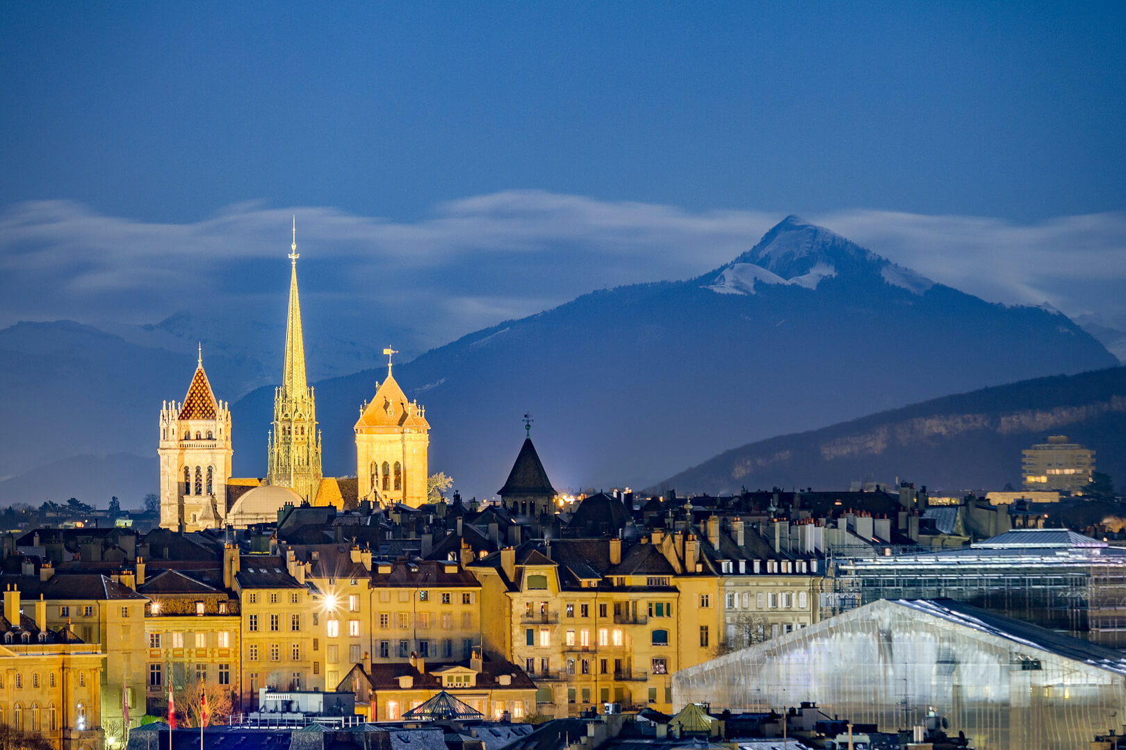Night view of Geneva with the Alps and the Saint Pierre Cathedral