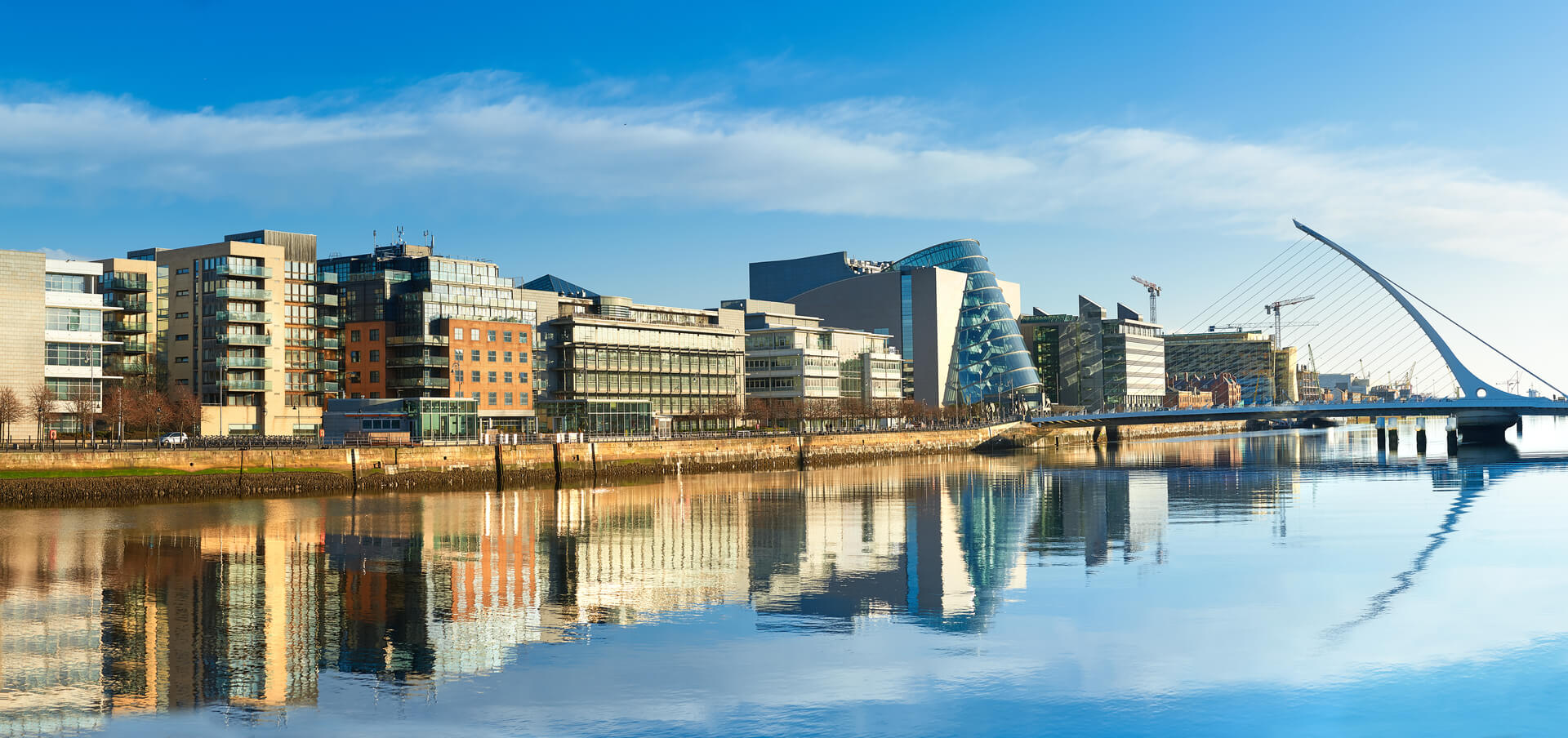 Bâtiments modernes et bureaux sur la rivière Liffey à Dublin par une journée ensoleillée, le pont sur la droite est le célèbre pont Harp.
