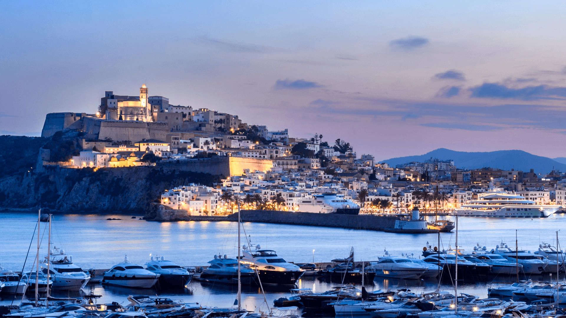 Ibiza, Espagne - 6 juin 2016 : Vue panoramique de la ville d'Ibiza et de son port au coucher du soleil. Le quartier monumental de Dalt Vila, inscrit au patrimoine mondial de l'humanité depuis 1999. Le port abrite de grands yachts.