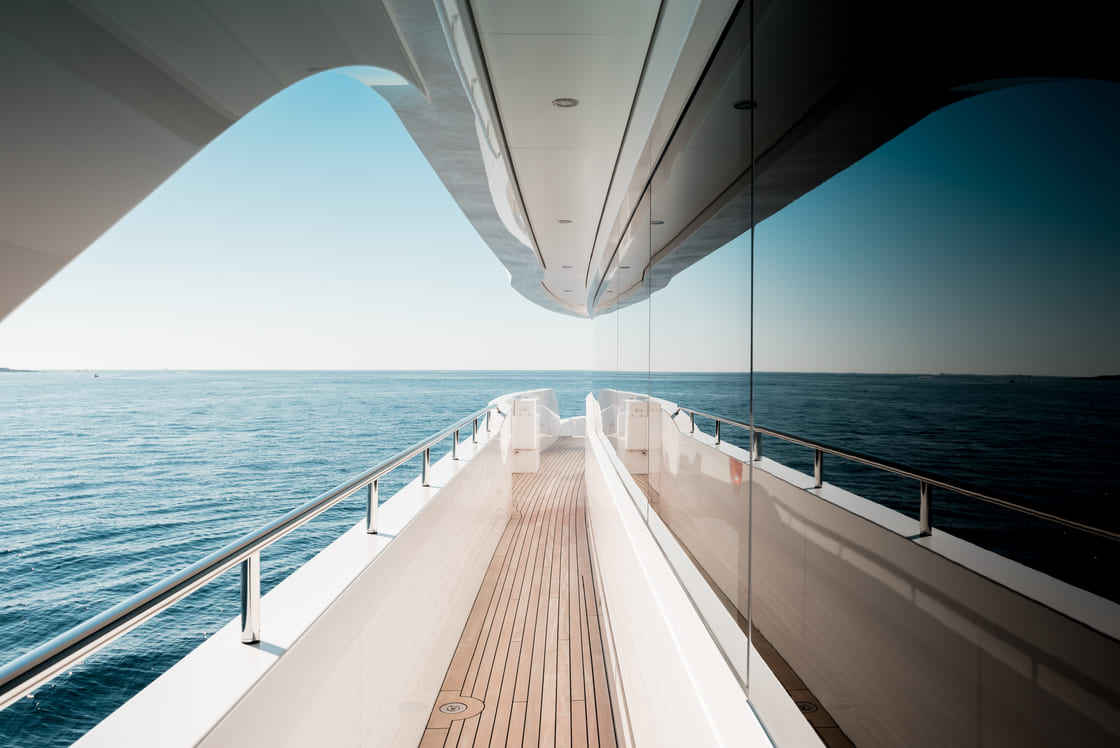 Beautiful detail of a superyacht upper deck corridor reflection on the glass windows, featuring the yacht's architectural design
