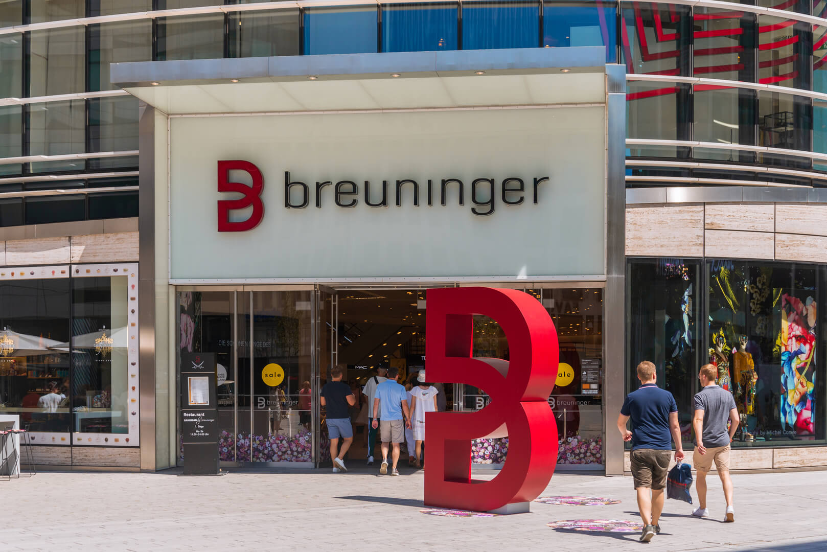 Outdoor sunny view in front of entrance of Breuninger luxury shopping mall at Schadowplatz, famous square is located inner city centre, in Düsseldorf, Germany.