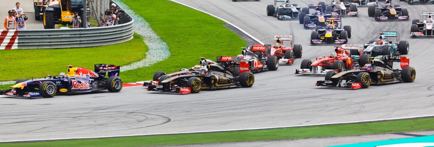 Seventeen formula one racing cars in a turn at the Hungarian F1 grand prix in Budapest