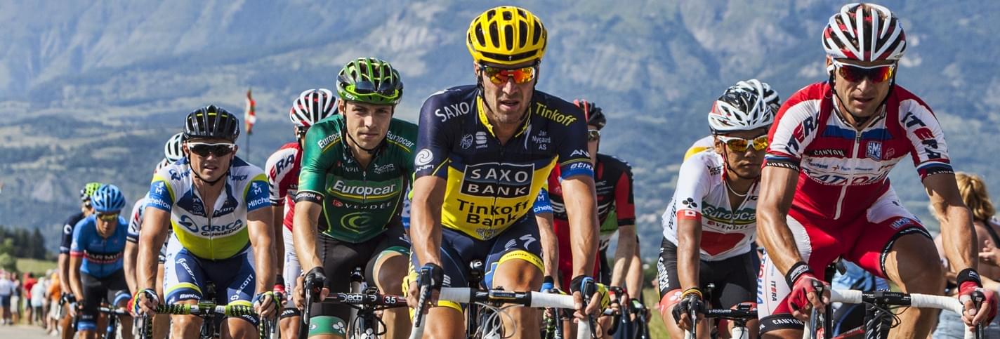 Plusieurs cylistes professionnels au Tour de France avec une montagne en arrière-plan