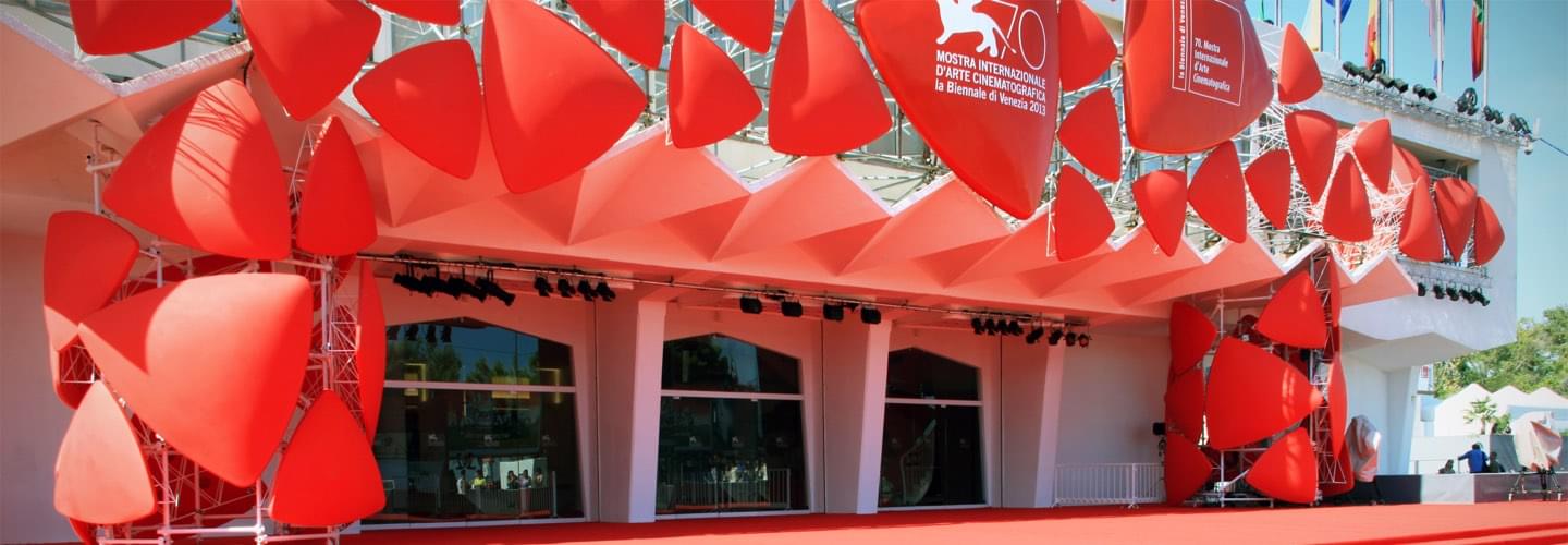 The entrance of the Venice International Film Festival with red structural elements in the sunlight 