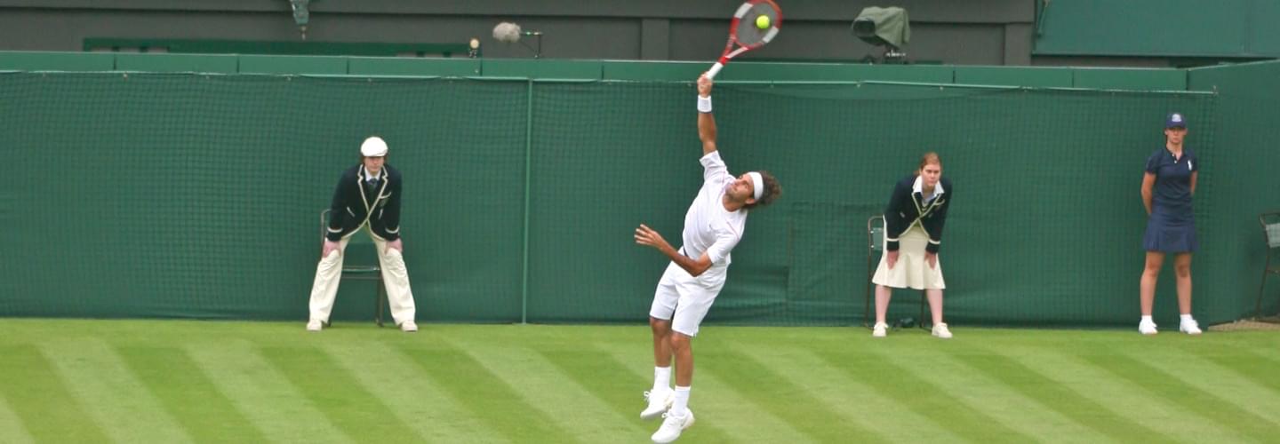 Roger Federer serving on a green grass court at the Wimbledon tennis tournament in London England
