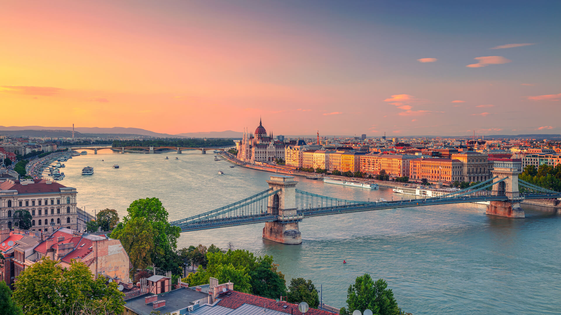 Будапешт, Венгрия. Панорамный снимок городского пейзажа Будапешта с цепным мостом Сечени и зданием парламента во время летнего заката