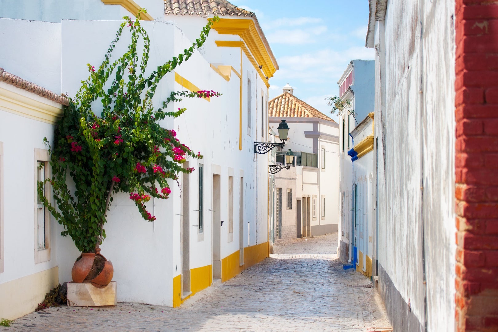 Enge Straße mit hellen Häusern in Faro