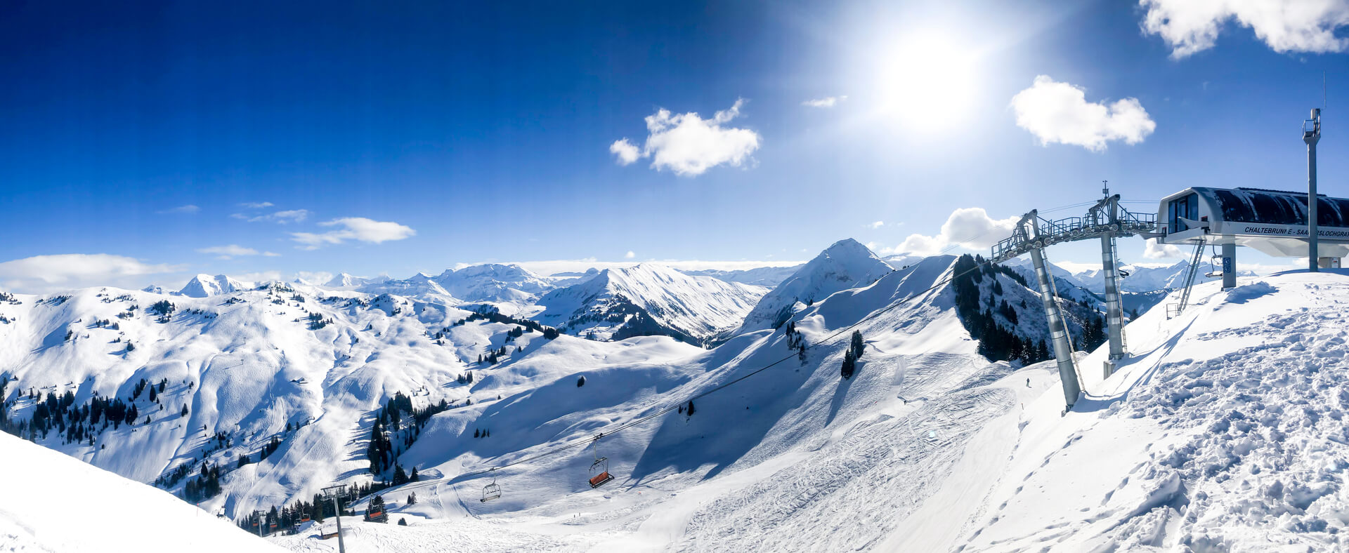 Télésiège devant la chaîne de montagnes des alpes suisses panorama par une journée ensoleillée avec un ciel bleu. télésiège à chaltebrunne saanerslochgrat en hiver. pistes de ski par une journée ensoleillée