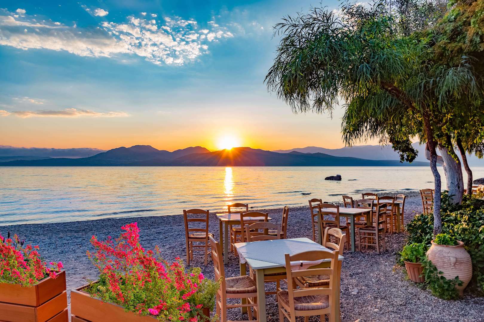 Tables and chairs on the beach on Lefkada at sunrise