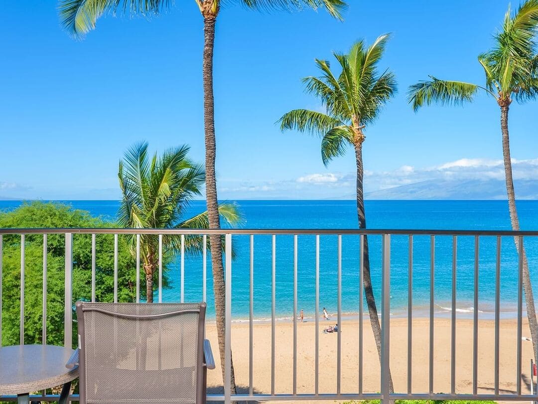 Blick auf den Strand von einem Hotelbalkon aus mit Blick auf Palmen, Meer und feinen Sand