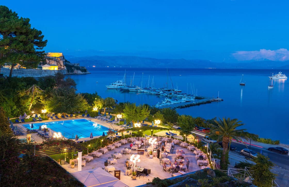 Corfu Palace Bay Yatch vor dem Meer, unterhalb des Restaurants und des Swimmingpools, im Hintergrund die beleuchtete Burg.