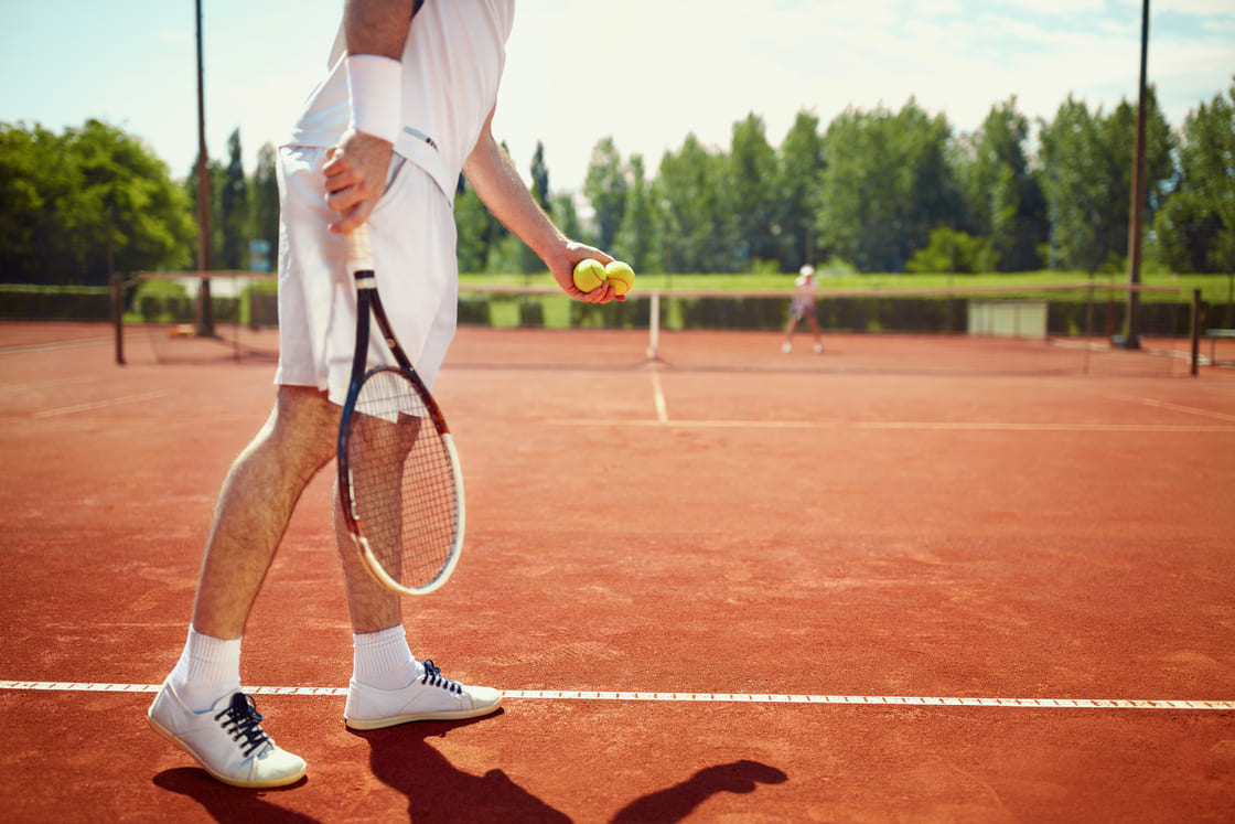 Ein Tennisspieler schlägt im Tennisclub von Korfu auf.