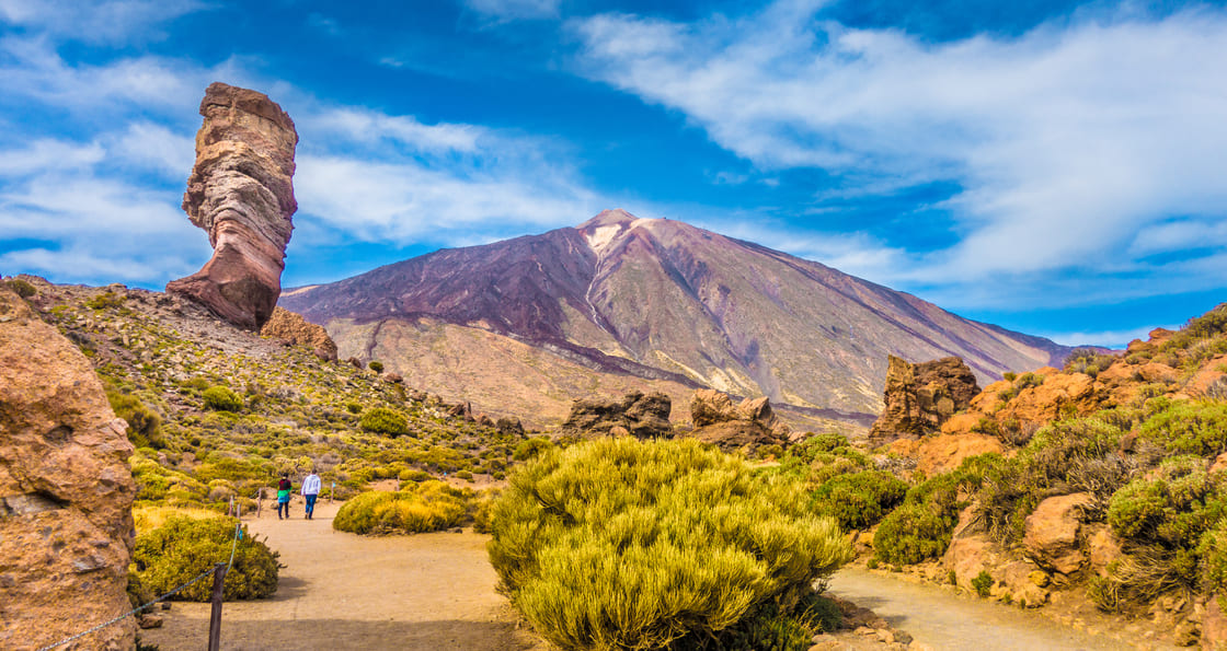 Vue panoramique de la formation rocheuse unique de Roque Cinchado avec le célèbre sommet du volcan de montagne Pico del Teide en arrière-plan par une journée ensoleillée, Parc National du Teide, Tenerife, Îles Canaries, Espagne
