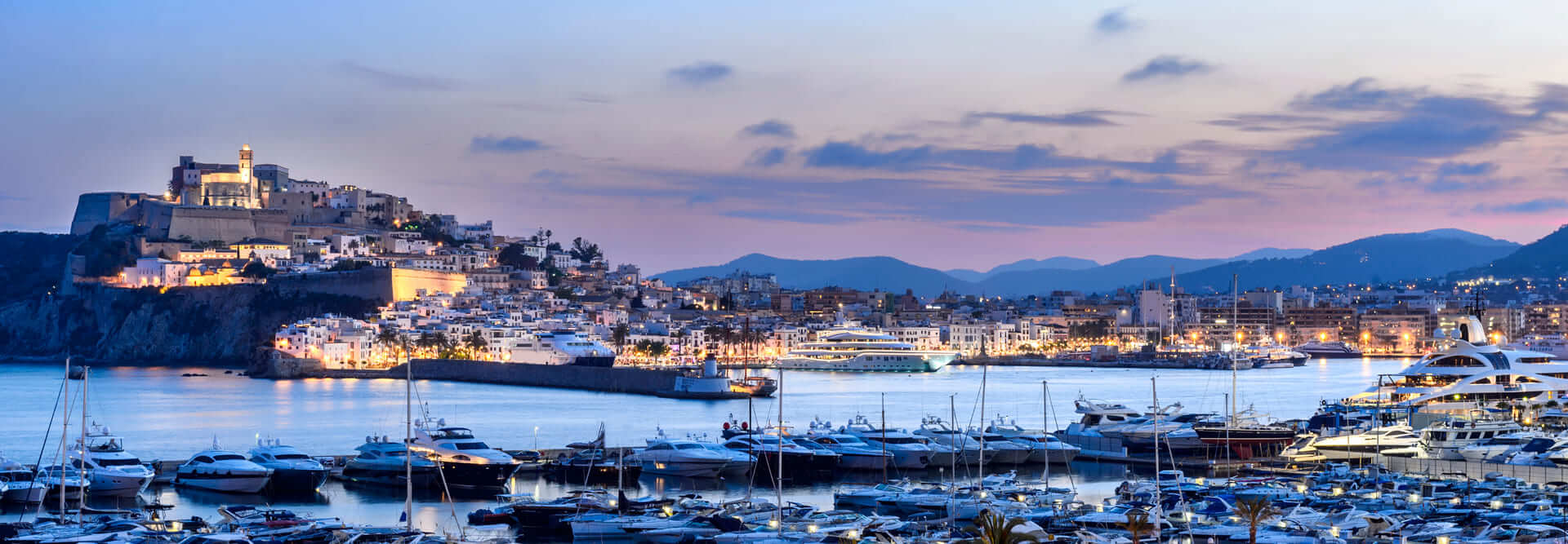 Ibiza, Spagna - 6 giugno 2016: Vista panoramica della città di Ibiza e del suo porto al tramonto. La zona monumentale di Dalt Vila, patrimonio dell'umanità dal 1999. Il porto ospita grandi yacht.