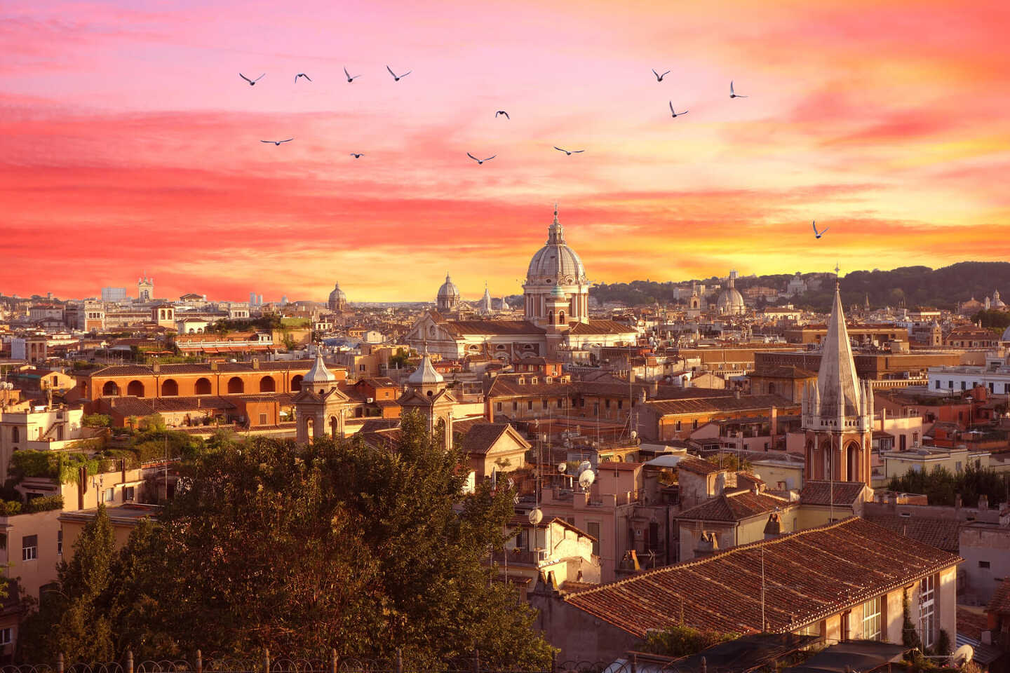 Rome avec le colisée à gauche et le coucher de soleil en arrière-plan