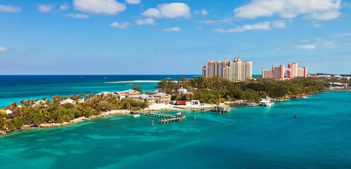 Un port donnant sur l'eau turquoise de la mer des carraibe avec des gratte-ciels en arrière plan à Nassau