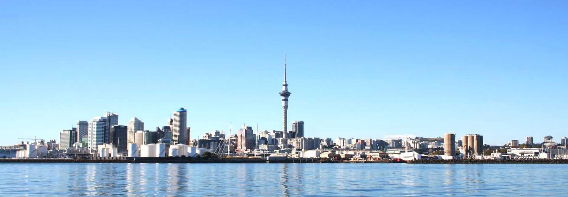 Photography of Auckland in New Zeland. The river in the foreground and the skyscrapers of the city center with the Sky Tower in the background.