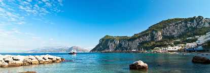 Una spiaggia di Capri, in Italia, con le sue acque turchesi e uno yacht