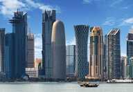 Skyline of Doha capital city of Qatar with skyscrappers and the sea by daylight