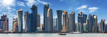 Skyline of Doha capital city of Qatar with skyscrappers and the sea by daylight