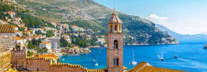 Photographie de Dubrovnik en Croatie, avec la tour de l'église, le monastère franciscain et des bateaux