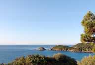 View of Figari coasts in Corsica with the sea and sailboats in a sunny cloudless afternoon