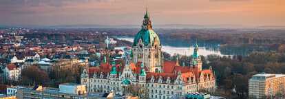Hannover’s New Town Hall at sunset with the Leine river on background