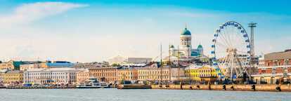 Photo of the city of Helsinki, on the forground, a river with some boats, on the background, the Uspenski Cathedral