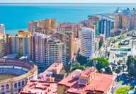 Sunny view of Malaga and its Malagueta bullring with the sea and harbour in the background